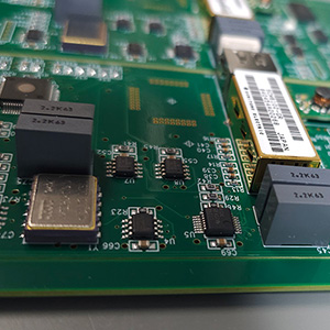 Close up of a circuit board, four small black microchips in the middle.